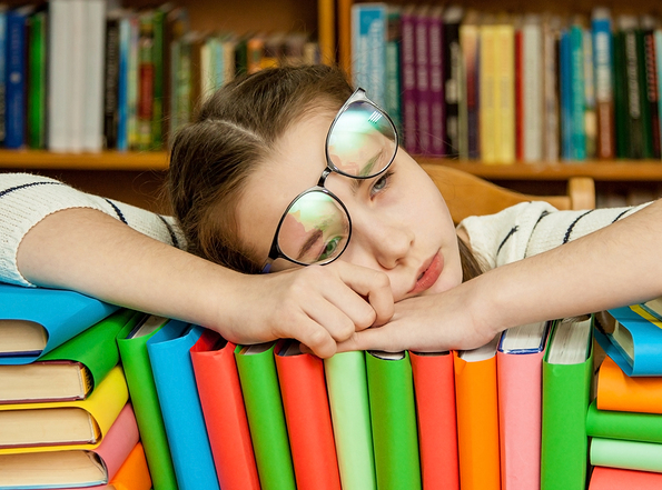 A decorative image of a young woman resting on a pile of books for this article on homeopathy for sleep problems.